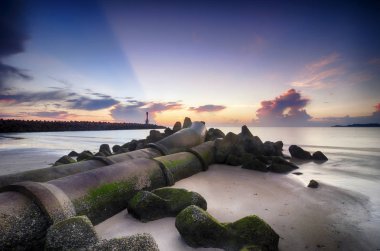Gündoğumu tropikal kumsalda çarpıcı. yosunlu boru hattı ve deniz feneri arka plan ışık güneş ışını ile