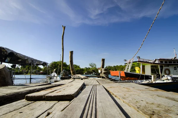 ahşap iskelesi ve tekne palamarla güneşli gün. yumuşak bulut ve mavi gökyüzü arka plan