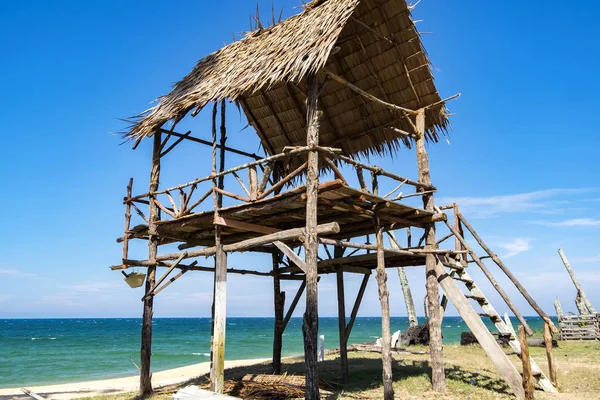 güneşli gün tropikal kumlu plaj ve mavi gökyüzü arka plan üzerinde ahşap kulübe