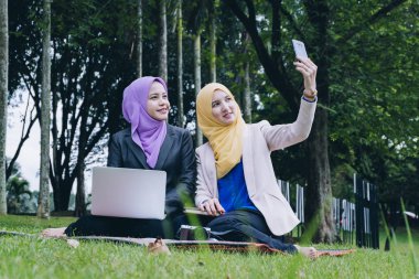 Birlikte vakit geçirmek, eğleniyor ve selfie Şehir Parkı yapım mutlu profesyonel muslimah