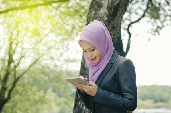 Sekme üzerine kentsel park background.sunlight ile takım elbiseli Genç profesyonel kadınlar etkisi ve metin için negatif yer flare