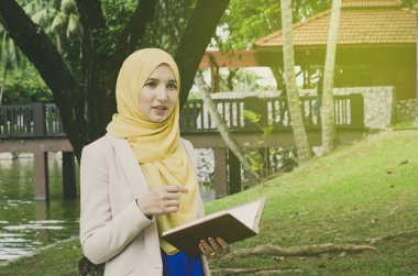 Eğitim kavramı, ayakta ve metin için park.negative yer defter tutan gülümsemek yüz genç muslimah kadın