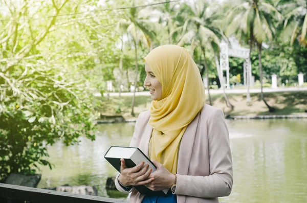 教育理念 微笑面对年轻的 Muslimah 女子站在公园里手持笔记本 文本的负空格 — 图库照片