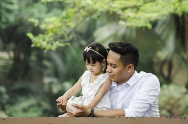 Genç Baba kızını doğa arka plan üzerinde para biriktirmek için öğretim