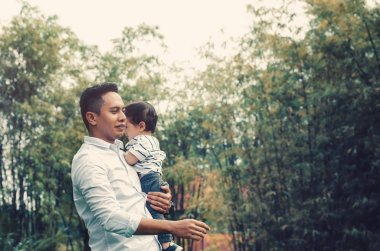 Genç baba oğlu mutlu aile kavramı için parlak güneşli bir günde altında Park'ta sarılma