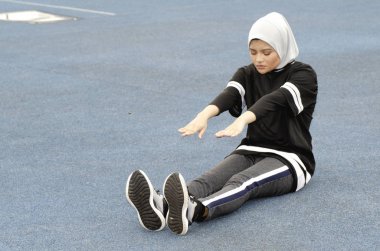 Spor ve sağlıklı yaşam konsepti. çalıştırmadan önce ısınma ve germe hijab ile genç atlet