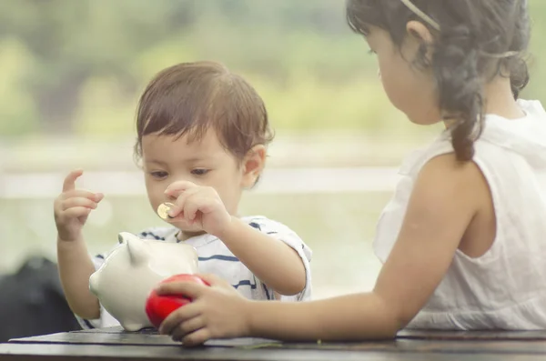 Saving Concept Two Little Kids Putting Coin Piggy Bank Future — Stock Photo, Image