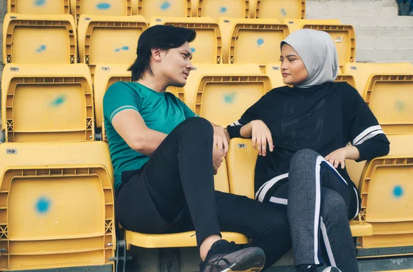 Portret młodego sportowca i kobieta siedzi i mówi do siebie — Zdjęcie stockowe