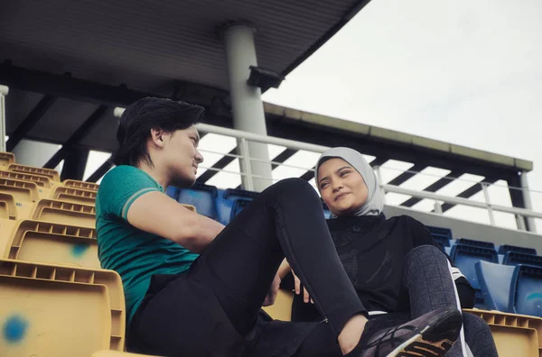 portrait of young sportsman and woman sitting and talking each other