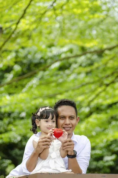 Padre joven pasar tiempo con su hija en el parque durante el fin de semana —  Fotos de Stock