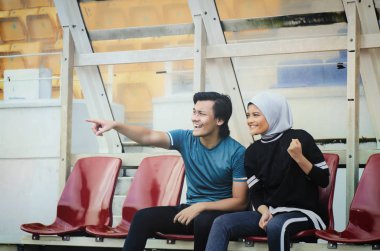 stadyumda eğlenmek ve kendi takımı için tezahürat genç çift oturmak