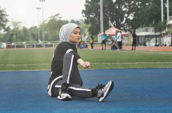 Sportvrouw zitten na Ken sommige rekken en opwarmen — Stockfoto