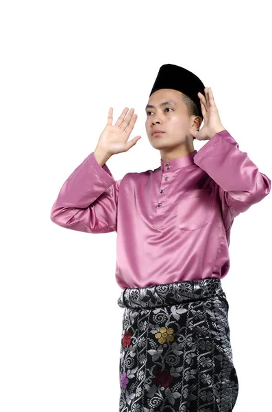 Bel homme asiatique avec des vêtements traditionnels levant la main pour prier sur fond blanc — Photo