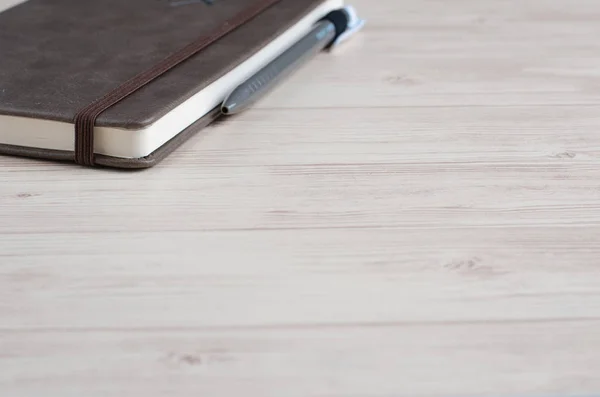 Makieta pamiętnik zamknięty z pióra na podłoże drewniane. — Zdjęcie stockowe