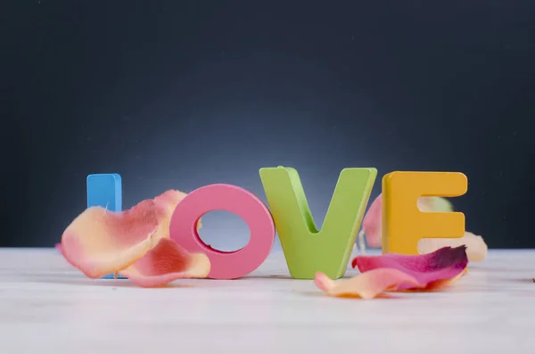 Красочные заглавные буквы слово ЛЮБОВЬ на деревянном столе для концепции Дня Святого Валентина — стоковое фото