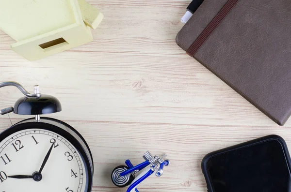 Lägenheten låg skrivbord med väckarklocka och dagbok över trä bakgrund — Stockfoto