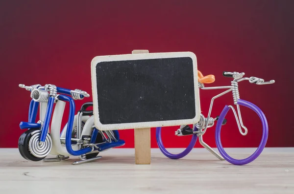 Miniature handcrafted scooter and bicycle on wooden desk shot over lighting effect — Stock Photo, Image