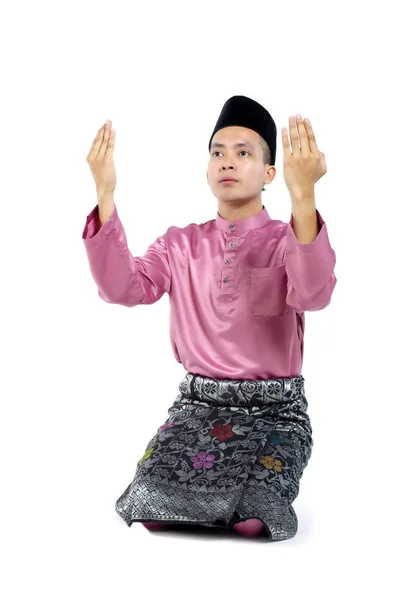 Jovem e bonito asiático homem com tradicional roupas levantando mão para rezar sobre branco fundo — Fotografia de Stock