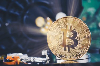 Altın Bitcoin üzerinde yavaşça aydınlatılmış koyu arka plan ve ışık ışını üzerinde sabit disk sökmek
