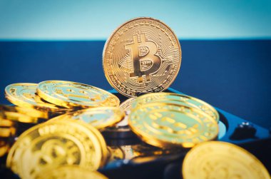 Altın Bitcoin üzerinde yavaşça aydınlatılmış koyu arka plan ve ışık ışını üzerinde sabit disk sökmek