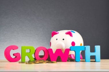 güzel yankı gradyan arka plan üzerinde ahşap masada sikke ve kelime Büyüme istifleme