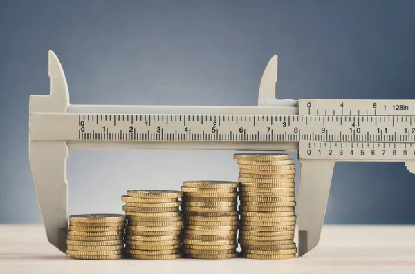 vernier kaliper ve güzel yankı gradyan arka plan üzerinde ahşap masa üzerinde sikke istifleme