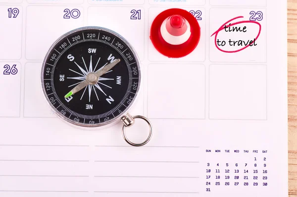 compass on planner calendar with word TIME TO TRAVEL