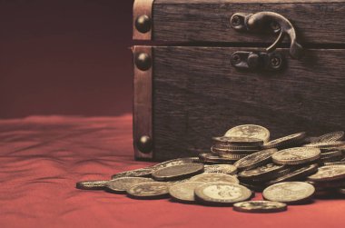 Finansal ve tasarruf para kavramı, ahşap kutu ve paralar kırmızı arka plan üzerine dökülen