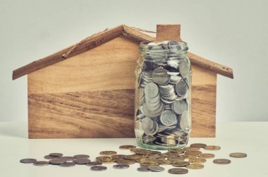 Mali ve kaydetme para kavramı, paralar cam dışarı dökülmesini ahşap masa