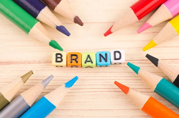 広告と商業マーケティングの概念のための木製の背景にカラフルなキューブワードブランド — ストック写真