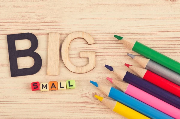 Conceito de negócio, lápis coloridos e palavra BIG SMALL em fundo de madeira — Fotografia de Stock