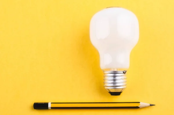 Lápiz y bombilla sobre fondo amarillo para el concepto de ideas creativas — Foto de Stock