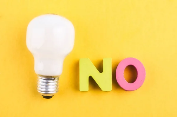 Palabra NO y bombilla sobre fondo amarillo —  Fotos de Stock