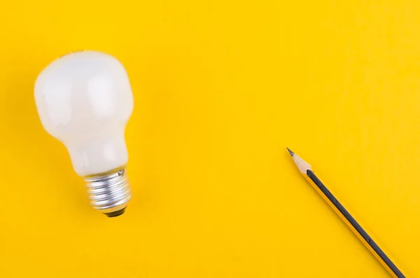 Lápiz y bombilla sobre fondo amarillo para ideas creativas cóncep — Foto de Stock