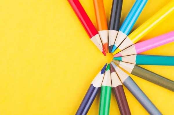 Close-up image of Colourful pencils over yellow background — Stock Photo, Image