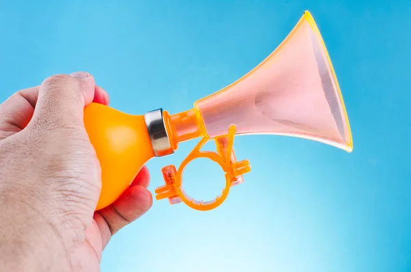 hand holding bike horn for warning or announce object over beautiful reverberation gradient background