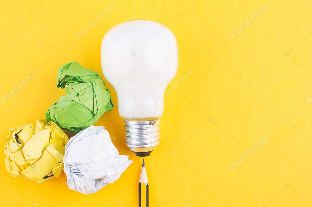pencil, crumple paper and bulb over yellow background for creative ideas concept