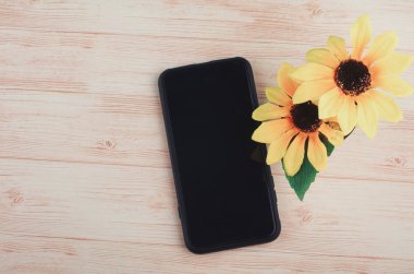 ahşap masa arka plan üzerinde akıllı telefon ve yapay bitki