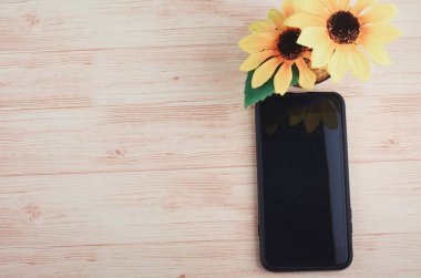 ahşap masa arka plan üzerinde akıllı telefon ve yapay bitki