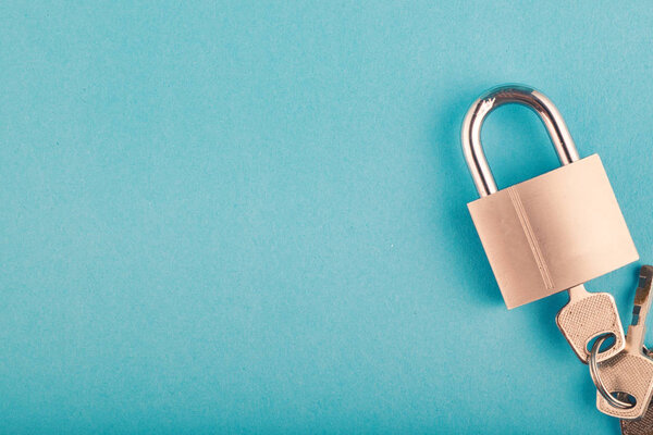 замок и связка ключей на синем фоне
