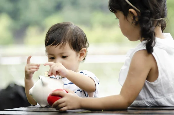 Concetto di risparmio finanziario e di pianificazione, i bambini che mettono monete nel salvadanaio — Foto Stock