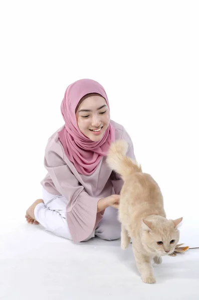 Mooie jonge hijab Muslimah spelen met haar kat over witte achtergrond — Stockfoto