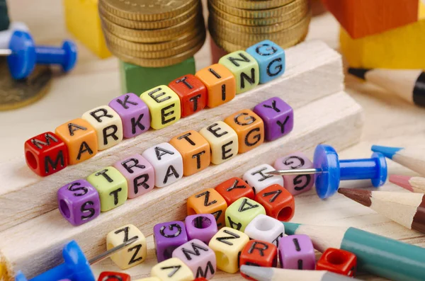 Koncept obchodní kampaně pozadí, barevná krychle s aplikací Word marketingová strategie na dřevěném stole — Stock fotografie