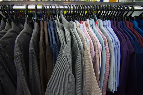 店舗販売コンセプトのためのショッピングモールでハンガーに掛かっている男性のための服のカラフルな選択 — ストック写真