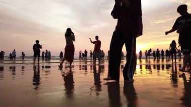 Sabah, Malezya - Eylül 2019: turist grubu deniz kıyısında gün batımı anını bekliyor