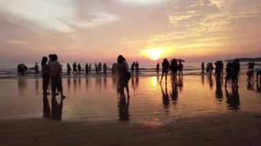 Sabah, Malezya - Eylül 2019: turist grubu deniz kıyısında gün batımı anını bekliyor