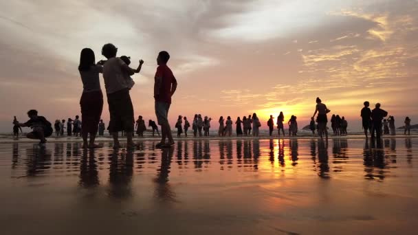 Sabah, Malajzia-szeptember 2019: csoport turisztikai élvezik várja a naplementét pillanatra a tengerparton — Stock videók