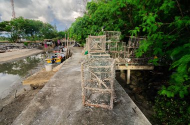 Dalgalar çekildiğinde yerel balıkçılar için beton iskele bulutlu arka planlara karşı.