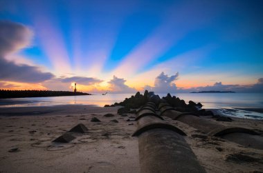Gün batımına karşı deniz manzarası ve kayalık plaj. Yumuşak ve tahıl efektli doğa bileşimi