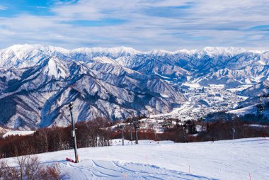 Japonya 'da kış mevsiminde yüksek dağdan manzara, beyaz kar ve güzel manzara mavi gökyüzü arka planına karşı